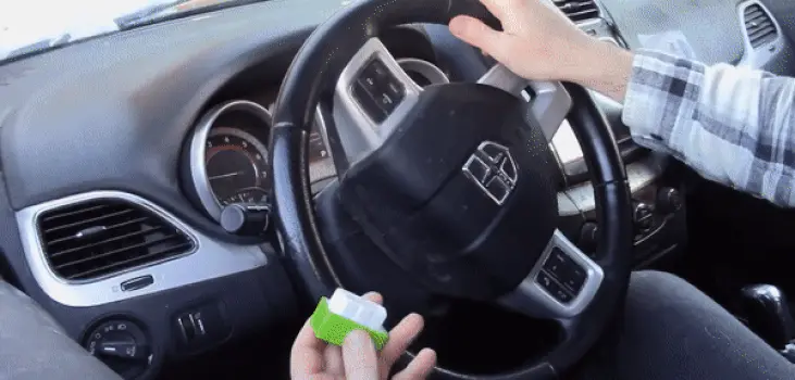 gif of man installing Electroinin Fuel Saver in his car